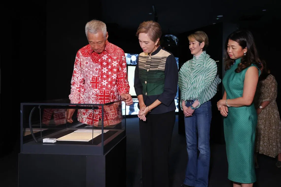 国务资政李显龙（左一）12月7日为“《信天翁档案》：解密独立史”常设展主持开幕式后参观展区， 包括建国总理李光耀在前副总理吴庆瑞口述访问逐字稿上留下的亲笔眉批。一同参观展览的有数码发展及新闻部长杨莉明（左二起）、担任展览执行创意总监的图书馆管理局总馆长兼创新总监陈惠勇，以及图管局总裁谭丽娟。（唐家鸿摄）