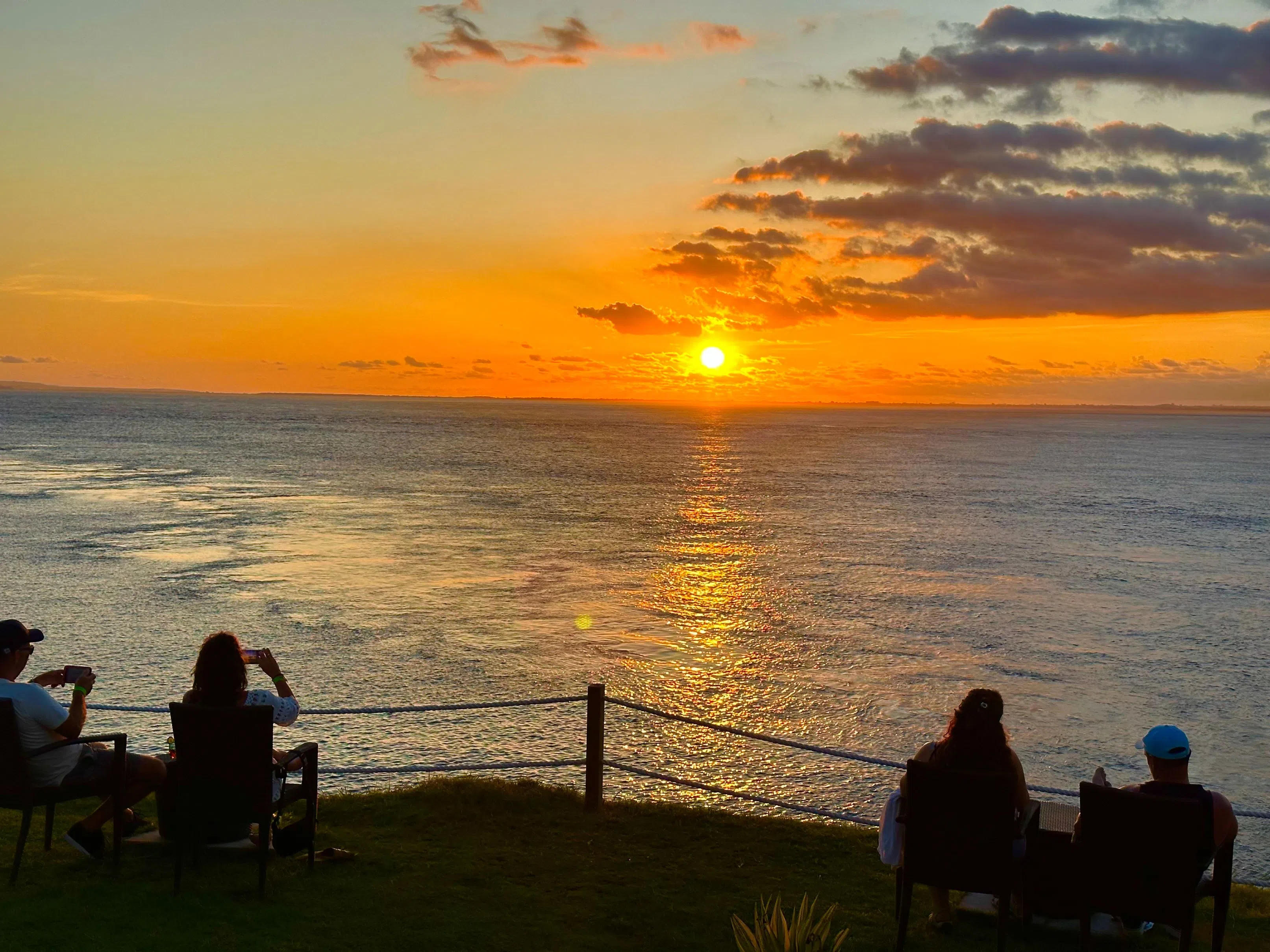 岛上有许多坐落在悬崖的上店家，傍晚时分人们纷纷前来点杯饮料等日落。（陈晓彤摄）