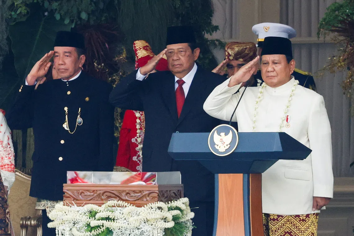 印尼总统普拉博沃（右起）、前总统尤多约诺和佐科，8月17日在雅加达总统府举办的独立80周年庆典上行注目礼。（路透社）