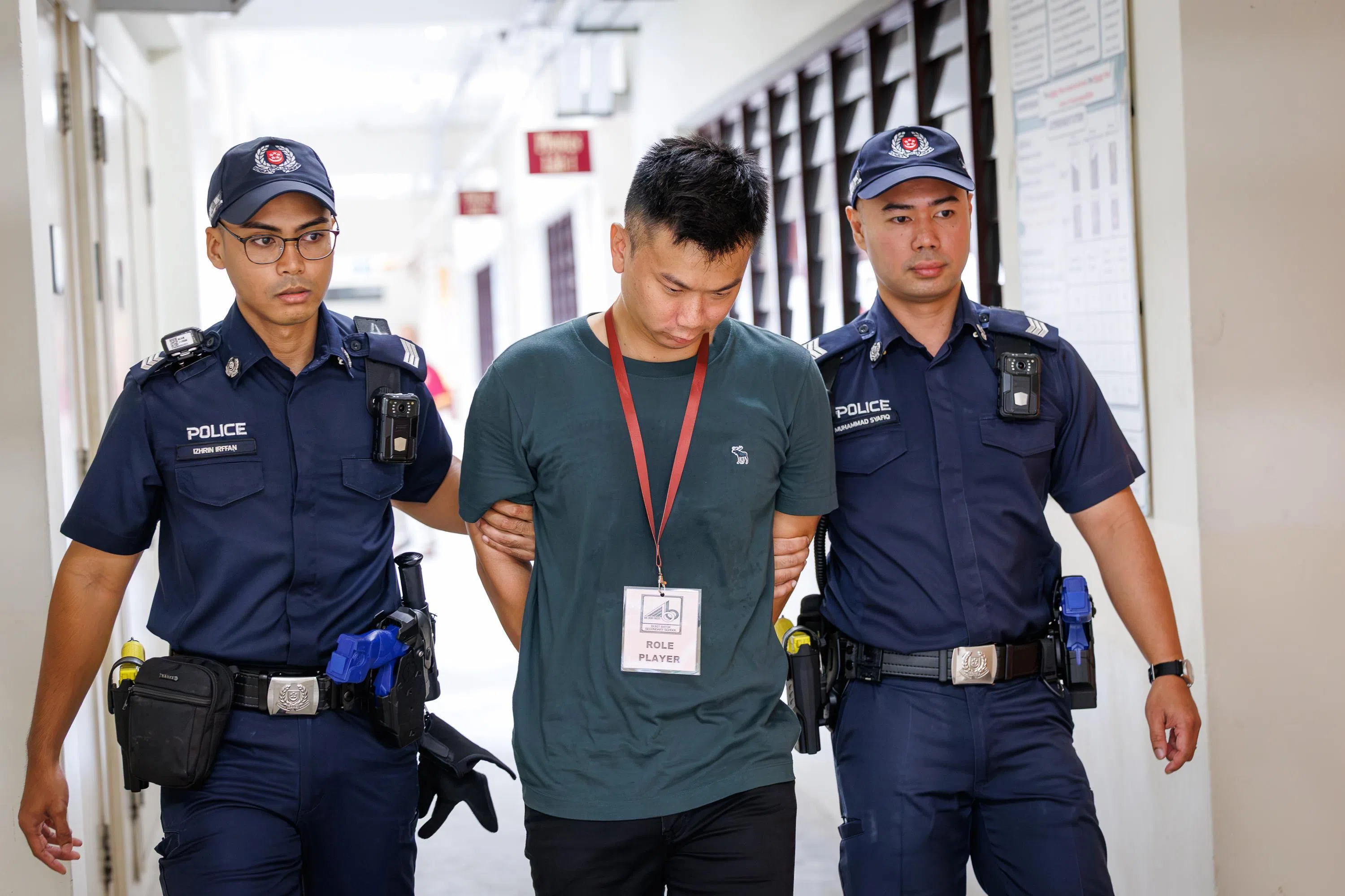 武吉巴督中学星期四（10月22日）在校内模拟的危机场景中，“持刀男子”被警方逮捕后，“全校封锁”演习才结束。（教育部提供）