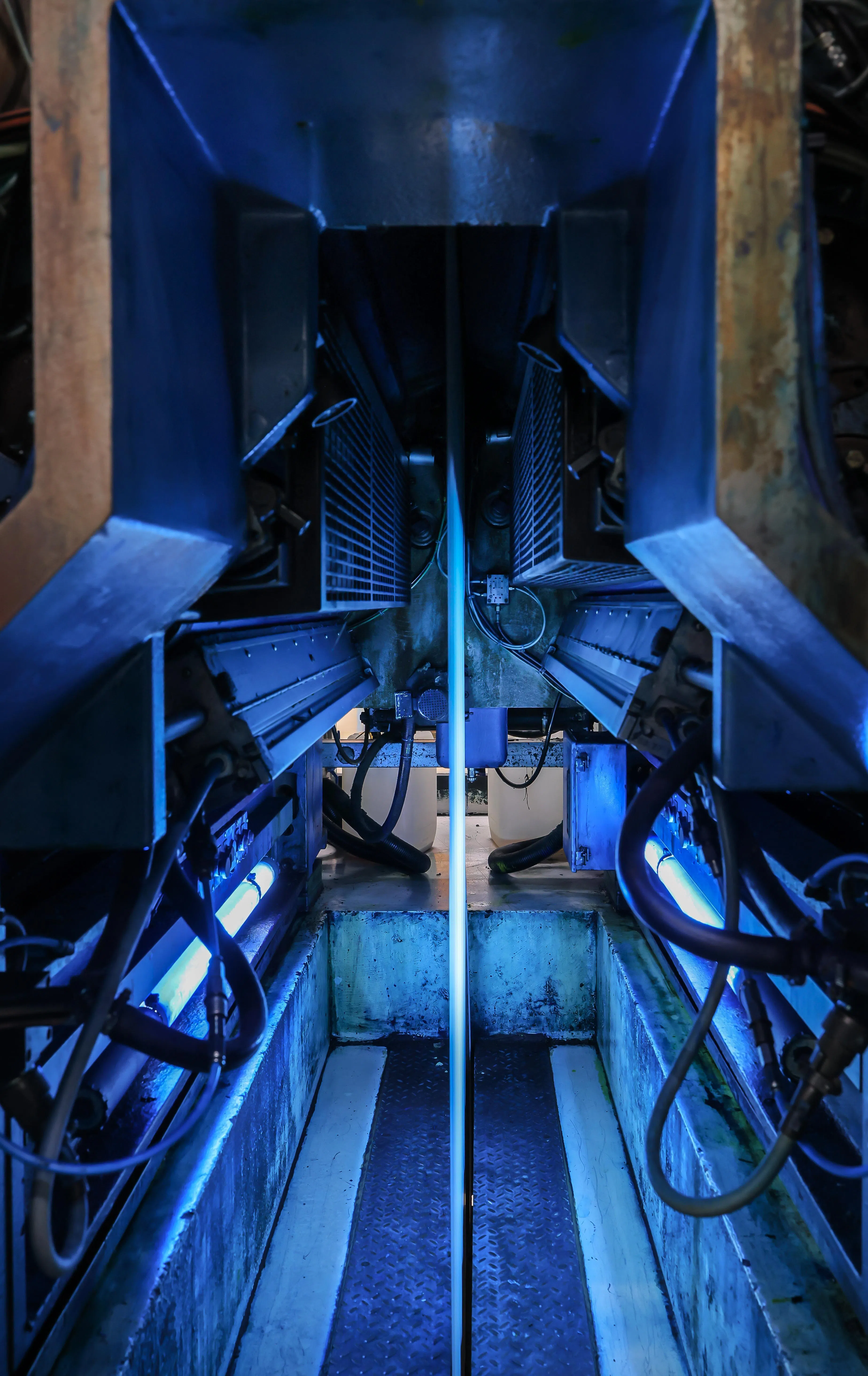 工作车间长期被蓝色油墨浸染，白色的印刷纸在灯光映照下如一条蓝线，等待被编织成故事。（龙国雄摄）