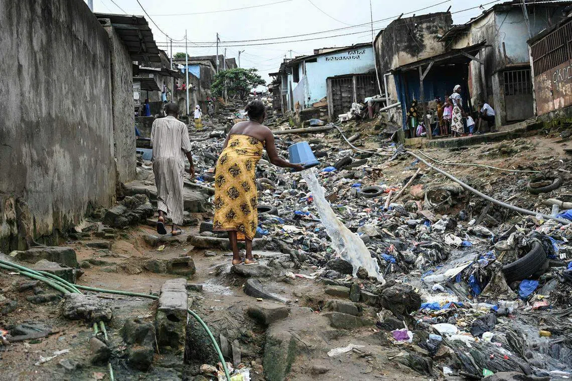 今年1月，一项发布在《美国国家科学院院刊》的新研究称，每公升瓶装水中含有11万到37万个颗粒，其中90%是纳米塑料，其余是微塑料。图为西非国家阿比让（Abidjan）让阿特库贝镇居民往布满垃圾的街道倒水。（法新社）