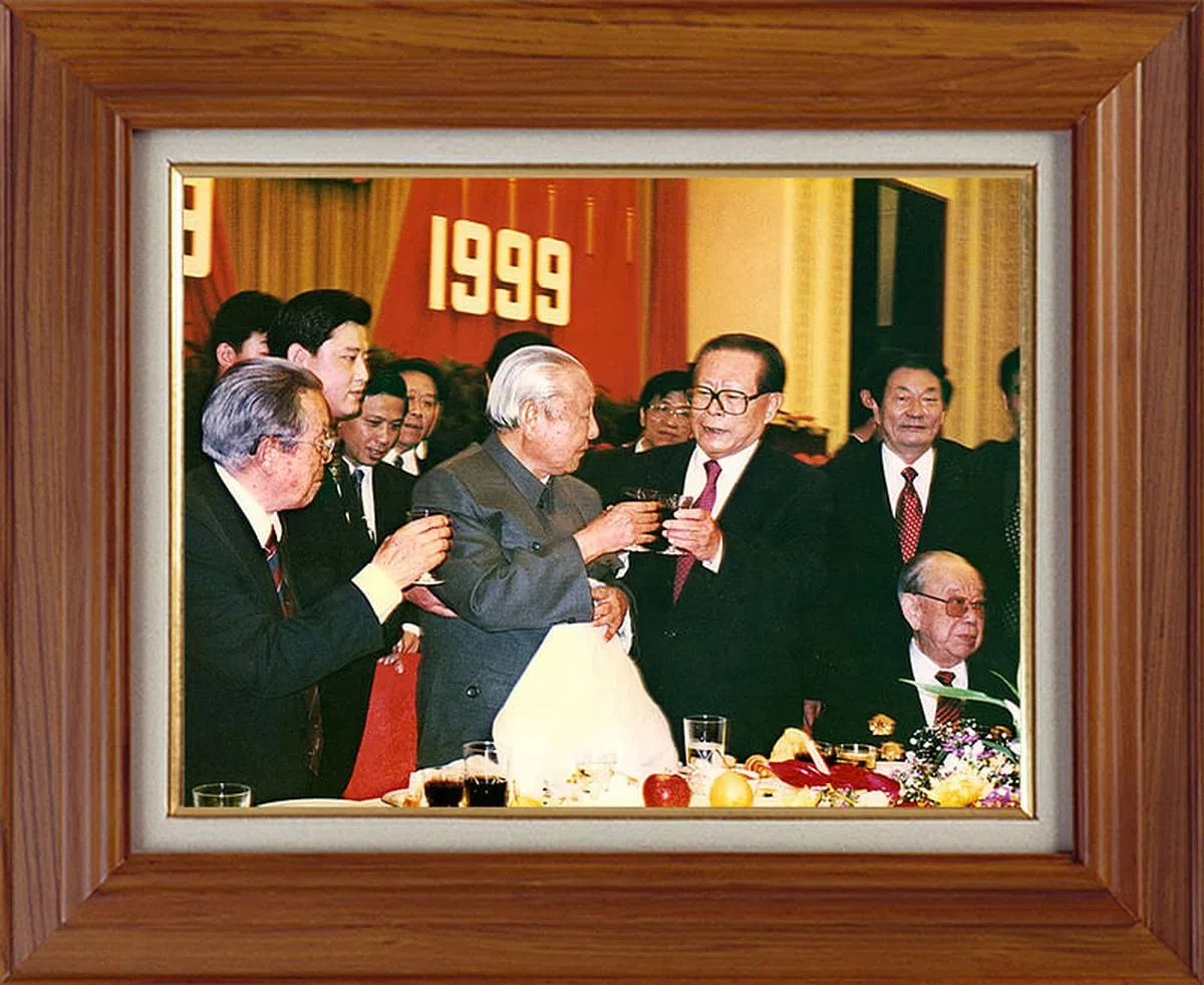 习近平发表新年贺词时，办公室书架上也摆放了一张江泽民和习仲勋等人在一起的合影。（新华社）