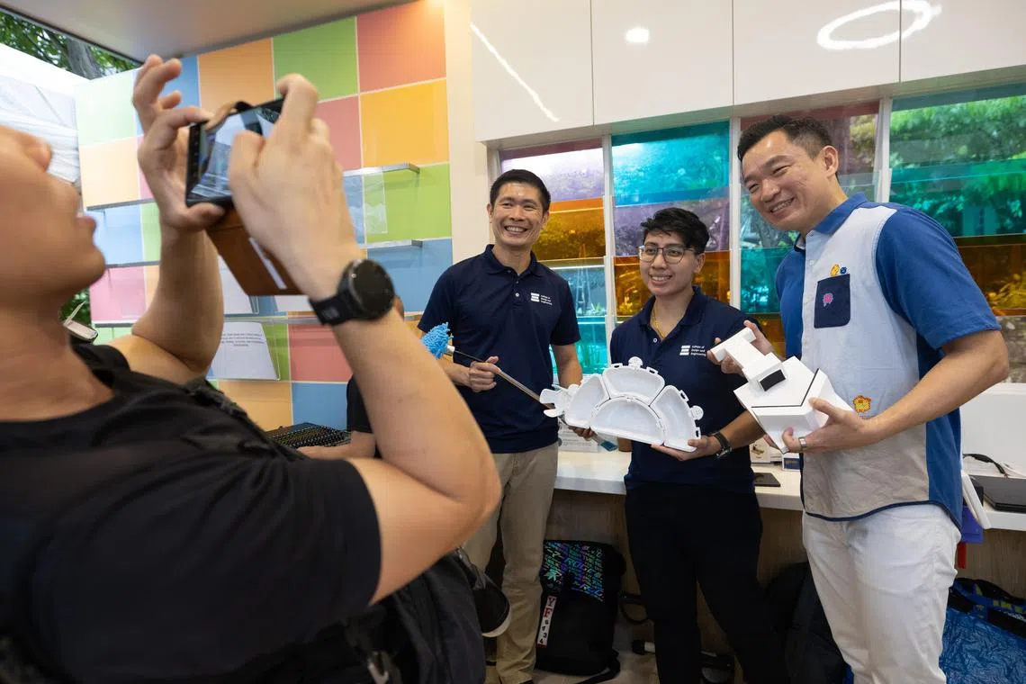 文化、社区及青年部兼社会及家庭发展部高级政务次长蔡瑞隆（右一）在女皇镇保健区首个社区参与活动中心开幕式现场，参观科研人员根据年长者需求改进设计的拖把、餐盒等生活用品。（特约沈康雄摄）