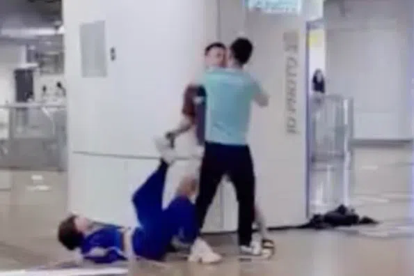 身穿浅蓝色上衣的男子试图劝架，他也与棕衣男子发生争执，还一度将对方按在柱子旁。（取自慈母舰）