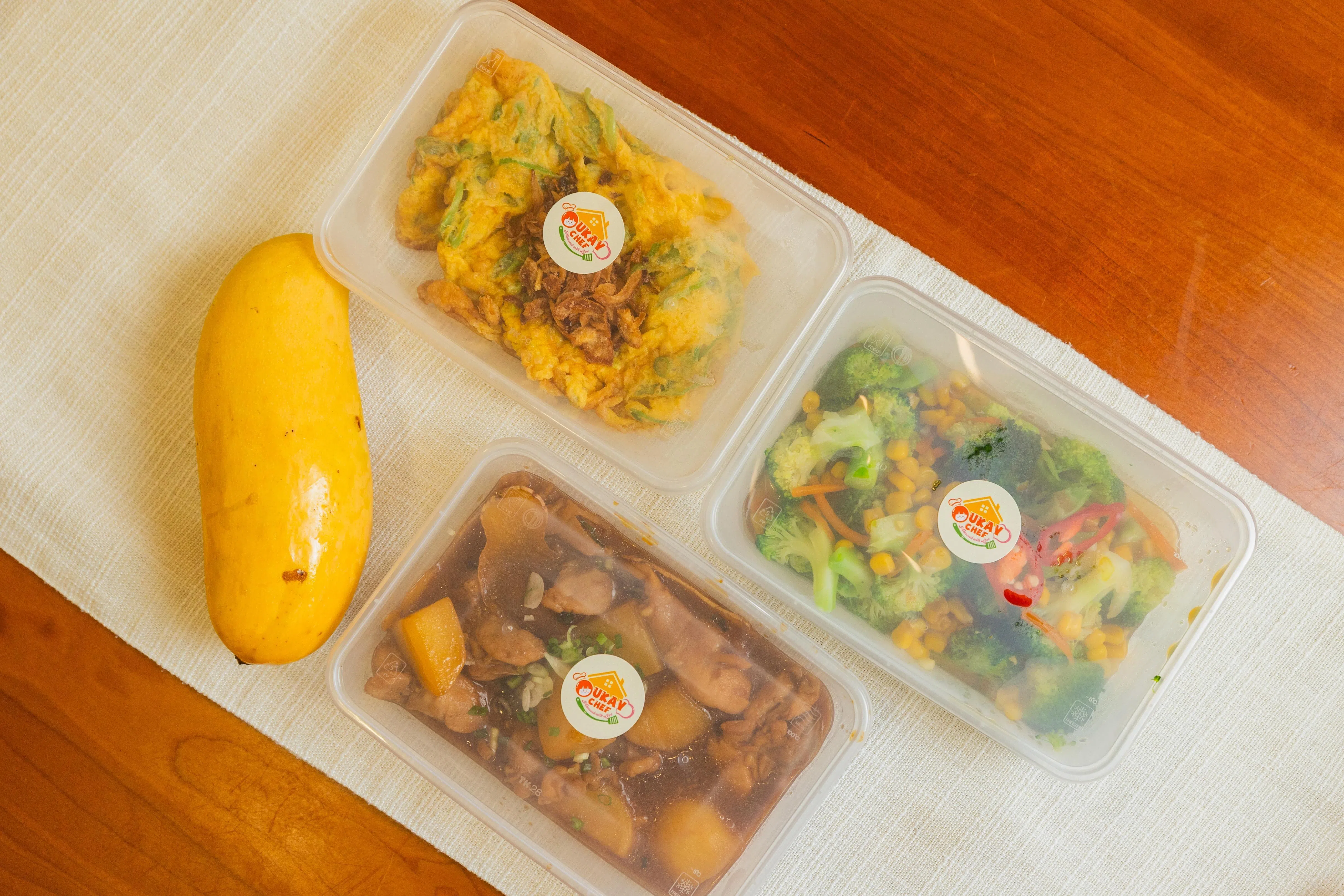 Oukay Chef的“三菜加一份水果”订餐宅配晚餐，包括：桂豆炒蛋、时菜西兰花、马铃薯焖鸡，还附送一个芒果。（吴先邦摄）