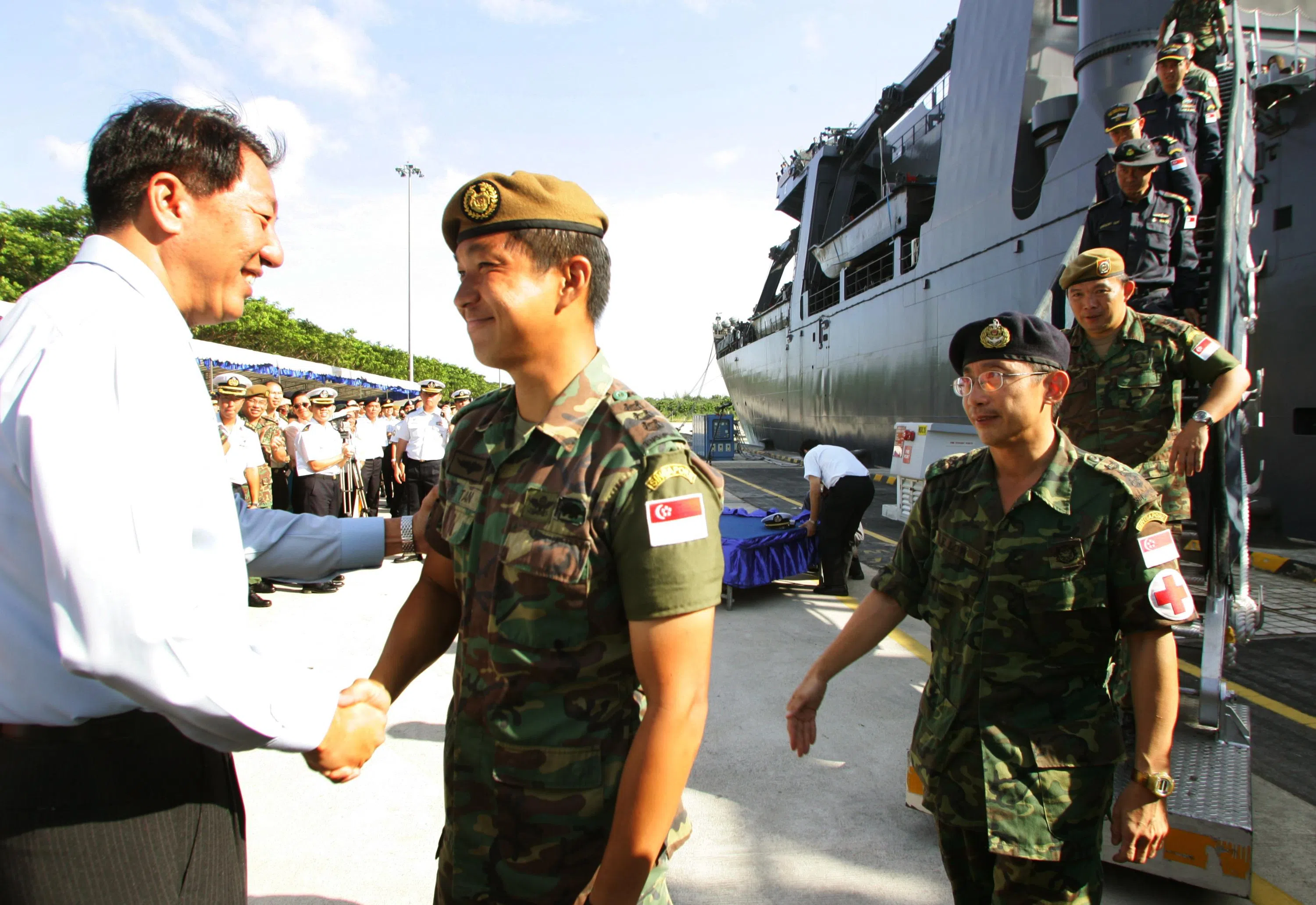 2005年1月24日，新加坡海军两艘登陆舰“坚韧号” （RSS Endurance）和“努力号”（RSS Endeavour）载着赴亚齐救灾的571名军人和57名非政府组织的义工回国。时任国防部长张志贤（左一）迎接顺利完成任务的武装部队人员回国，并向当时特遣部队指挥官陈川仁上校（左二）致意。（档案照片）