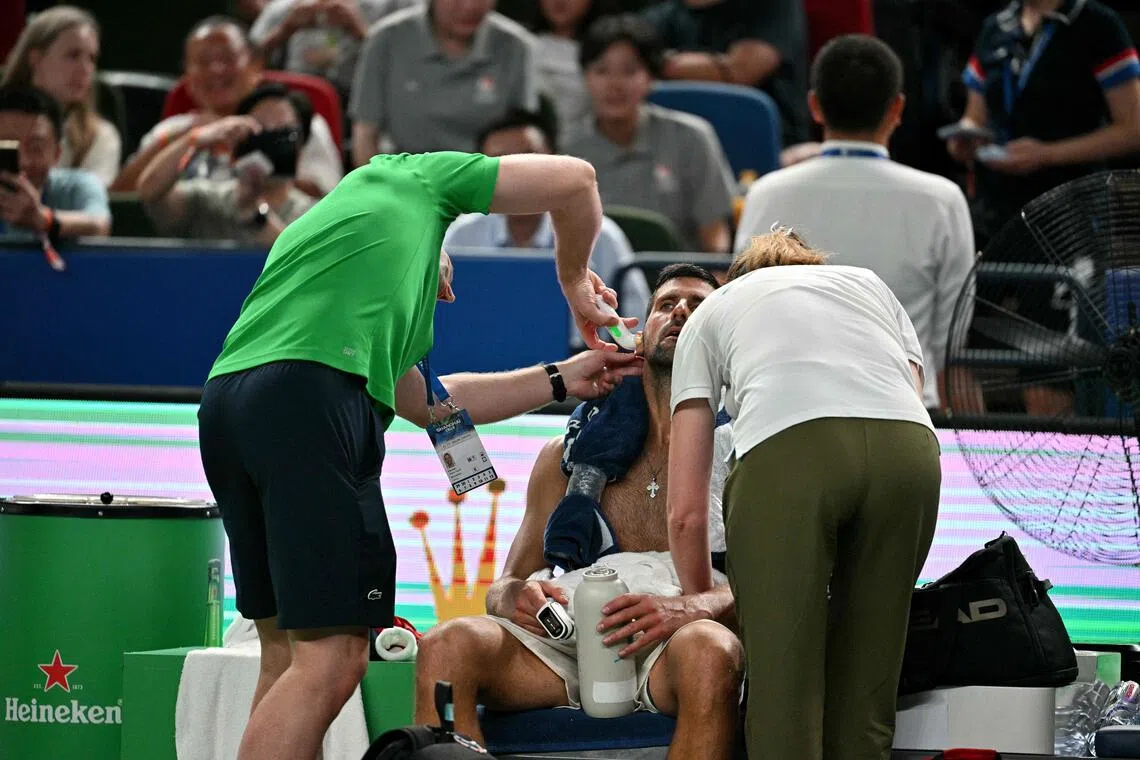 对垒穆纳尔的比赛中，乔科维奇（中）在高温下显露疲态，接受检查。（法新社）