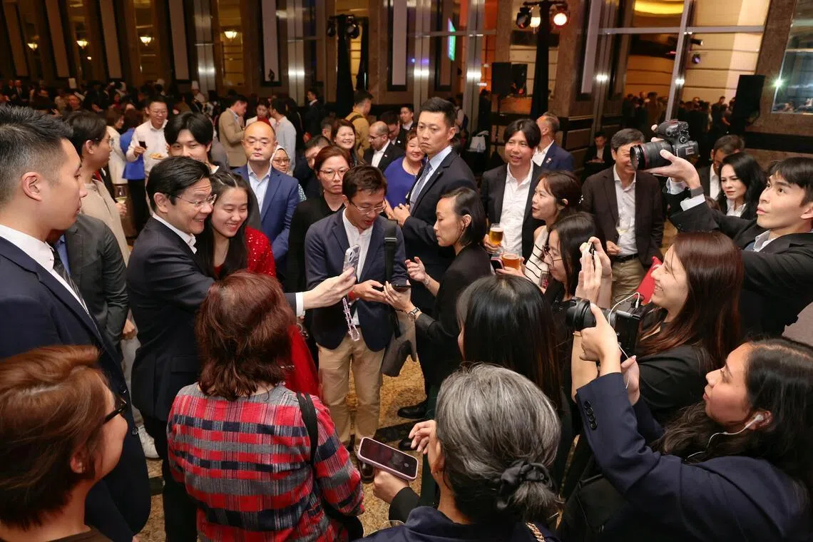 黄循财总理（左二）3月27日在新加坡人招待会上和与会者自拍，当中包括16岁的新加坡人蒋恩萱（左三，红衣）。（海峡时报）