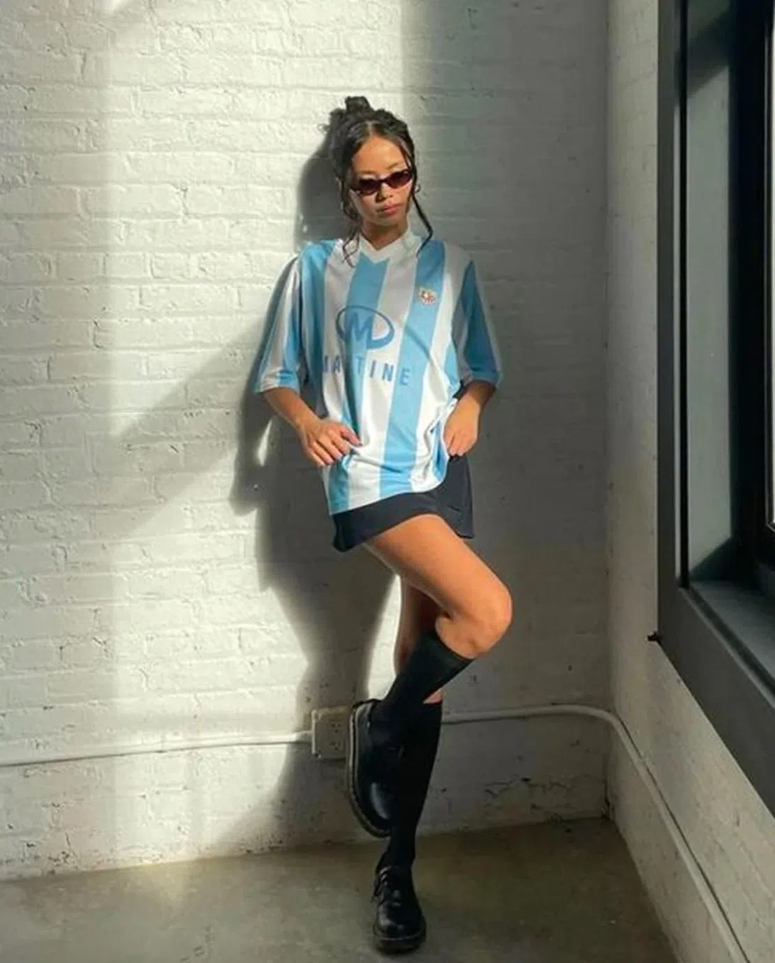 Blackpink的Jennie上身球衣，下身英伦女学生的混搭不但不违和，还飘散浓浓少女风。（互联网）
