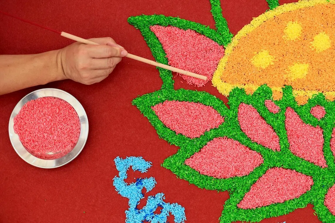 余义源以食用色素为白米染色，祝福信徒的人生如米图般丰富多彩。（龙国雄摄）