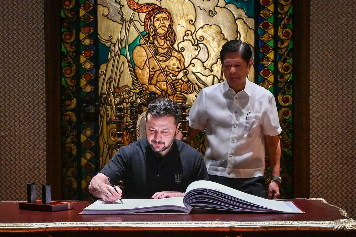 马尼拉新闻共享平台发布了多张照片，显示泽连斯基在小马可斯的陪同下，在菲律宾总统府贵宾册上留言。（法新社）