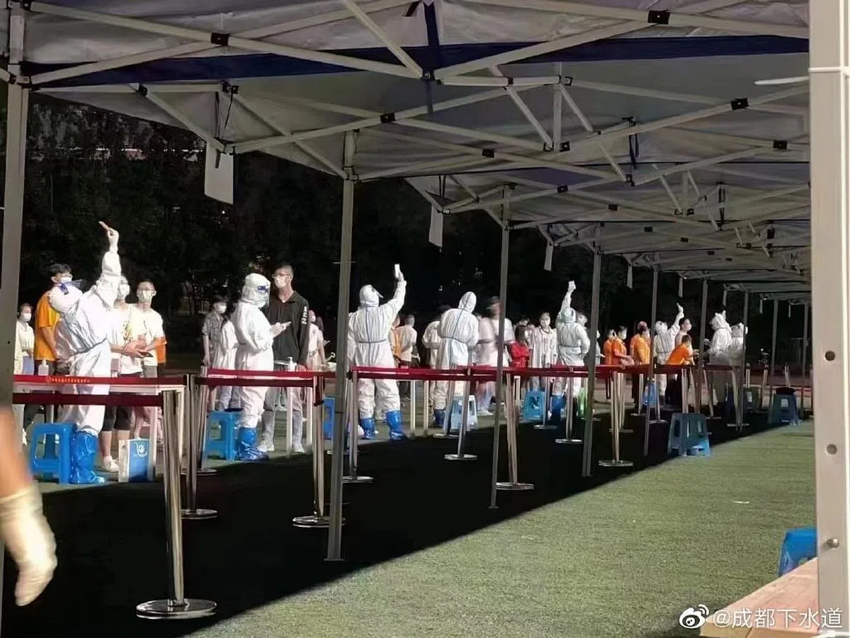 成都核酸系统崩溃，现场多名医护人员误以为信号不好，将手机高举过头顶尝试获取信号。（微博）