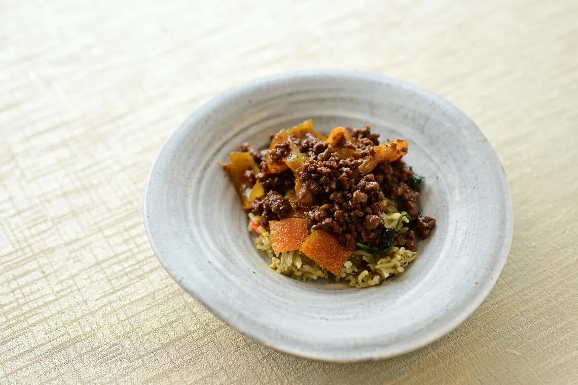 Le Du餐馆泰国厨师Ton和鸿桃轩钟腱腾为限时活动合创一道新中炒饭——花胶罗勒肉碎乳猪咸酸菜炒饭。（餐馆提供）