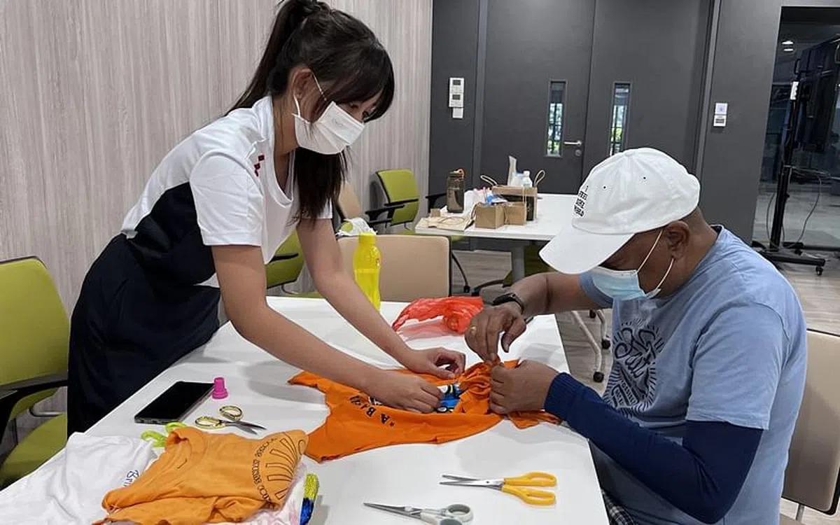 裕驱初院的同学们教乐龄人士如何将旧衣服做成环保手提袋。（裕驱初院扶轮少年服务团提供）