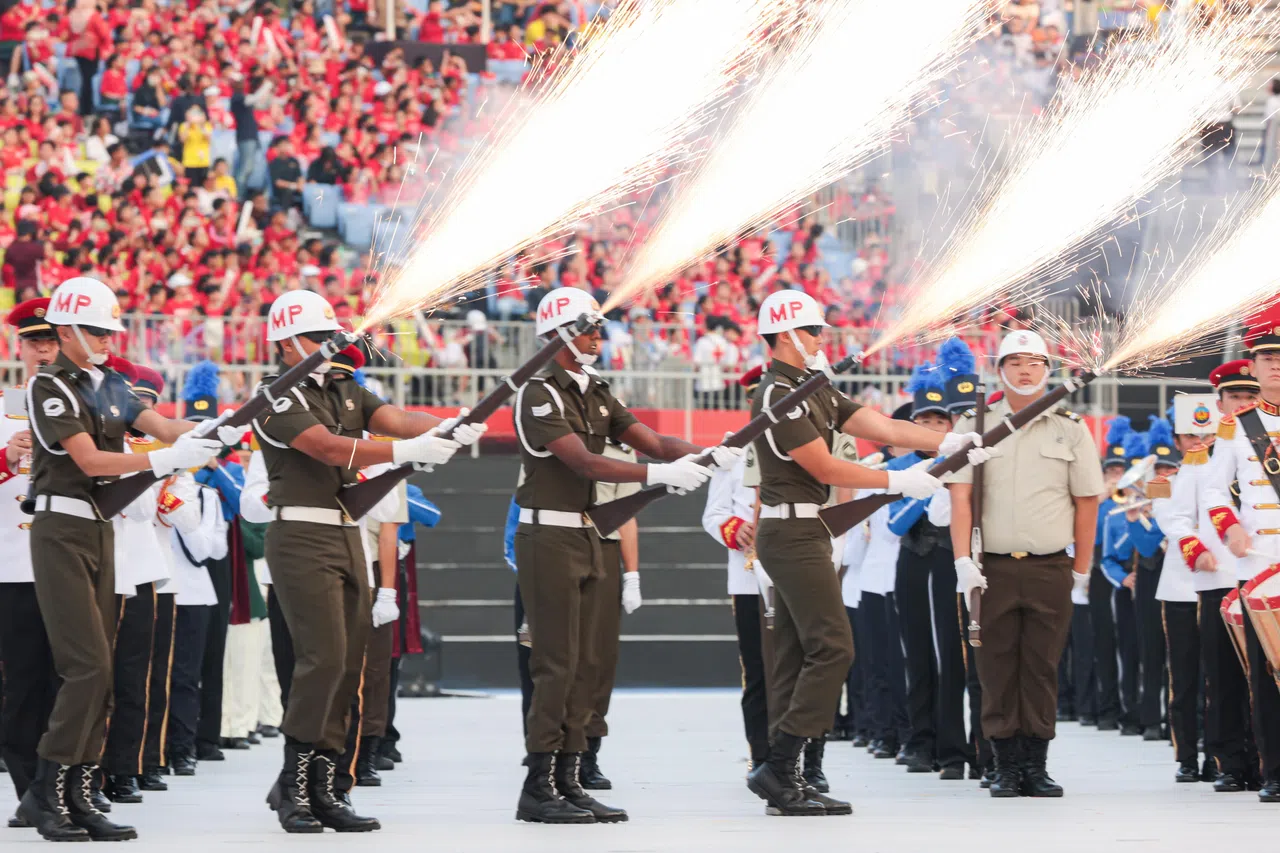 新加坡武装部队宪兵精准步操队在军乐伴奏下呈献操枪表演，现场顿时“火花四射”。（李冠卫摄）