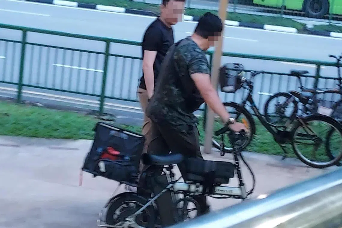 身穿便衣相信是执法人员的男子，将违规的电动脚踏车带走。（受访者提供）