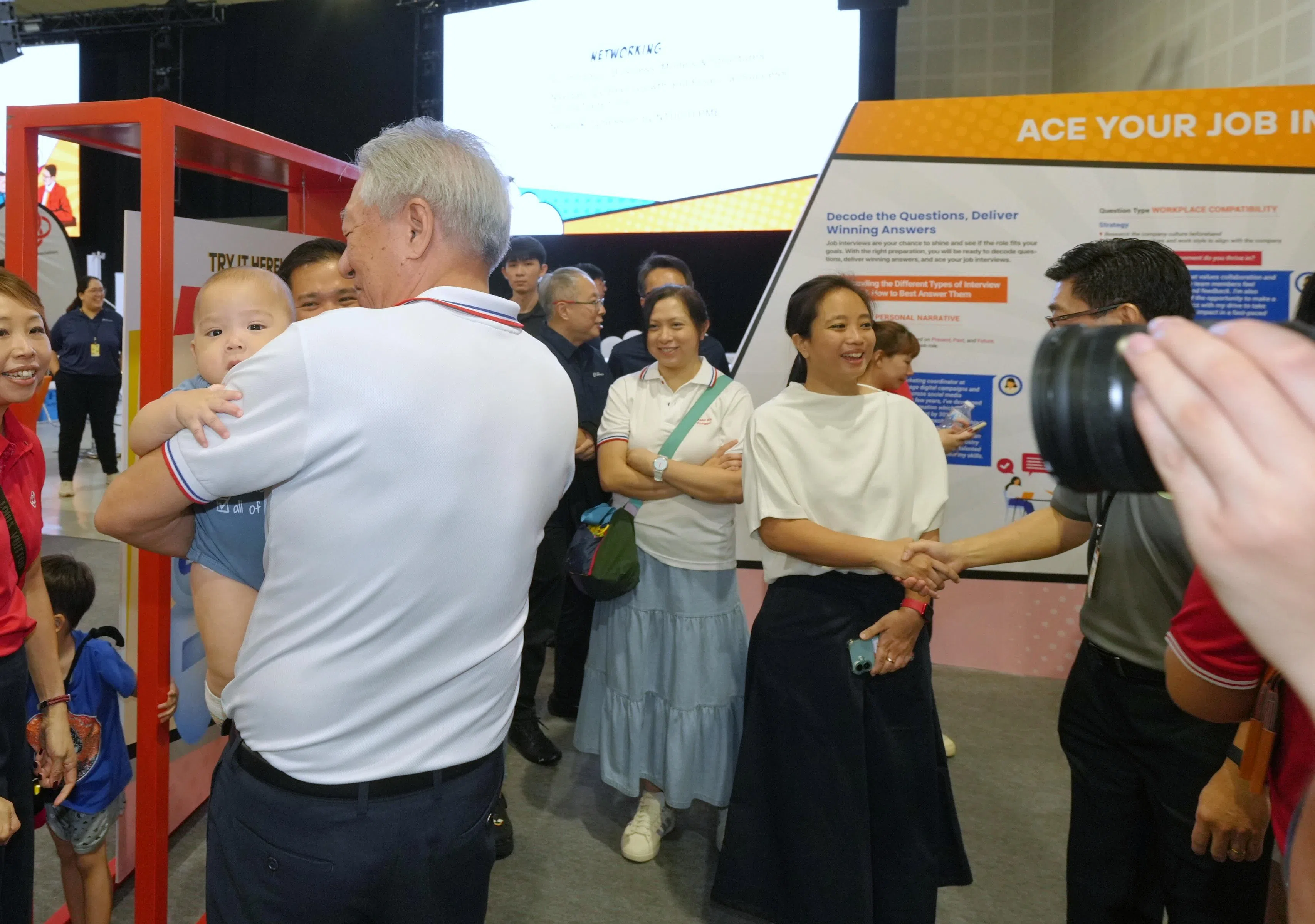 行动党新面孔李乃怡（右二）首次受邀出席白沙—榜鹅集选区的职业展活动。背对镜头的是国务资政兼国家安全统筹部长张志贤。（谢智扬摄）