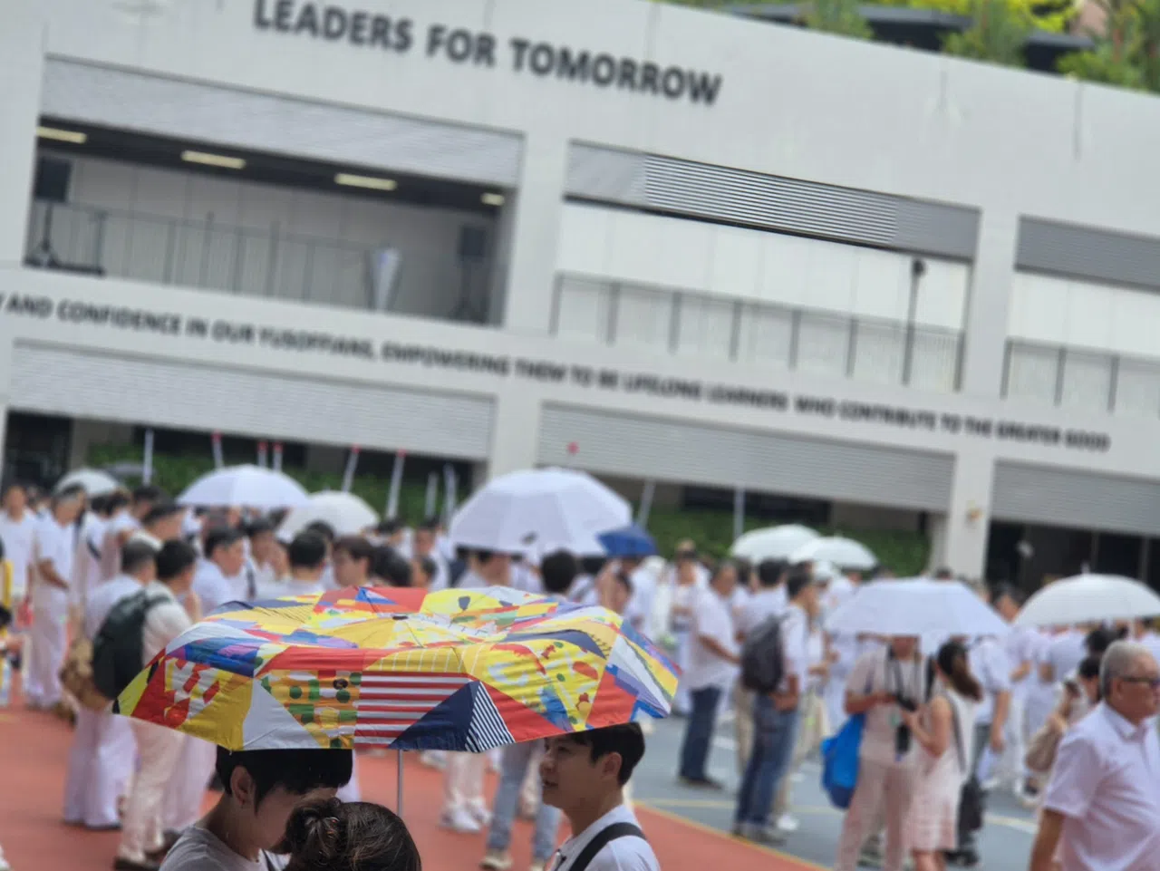这把五彩缤纷的雨伞在“蓝白对决”中格外醒目。（陈爱薇摄）