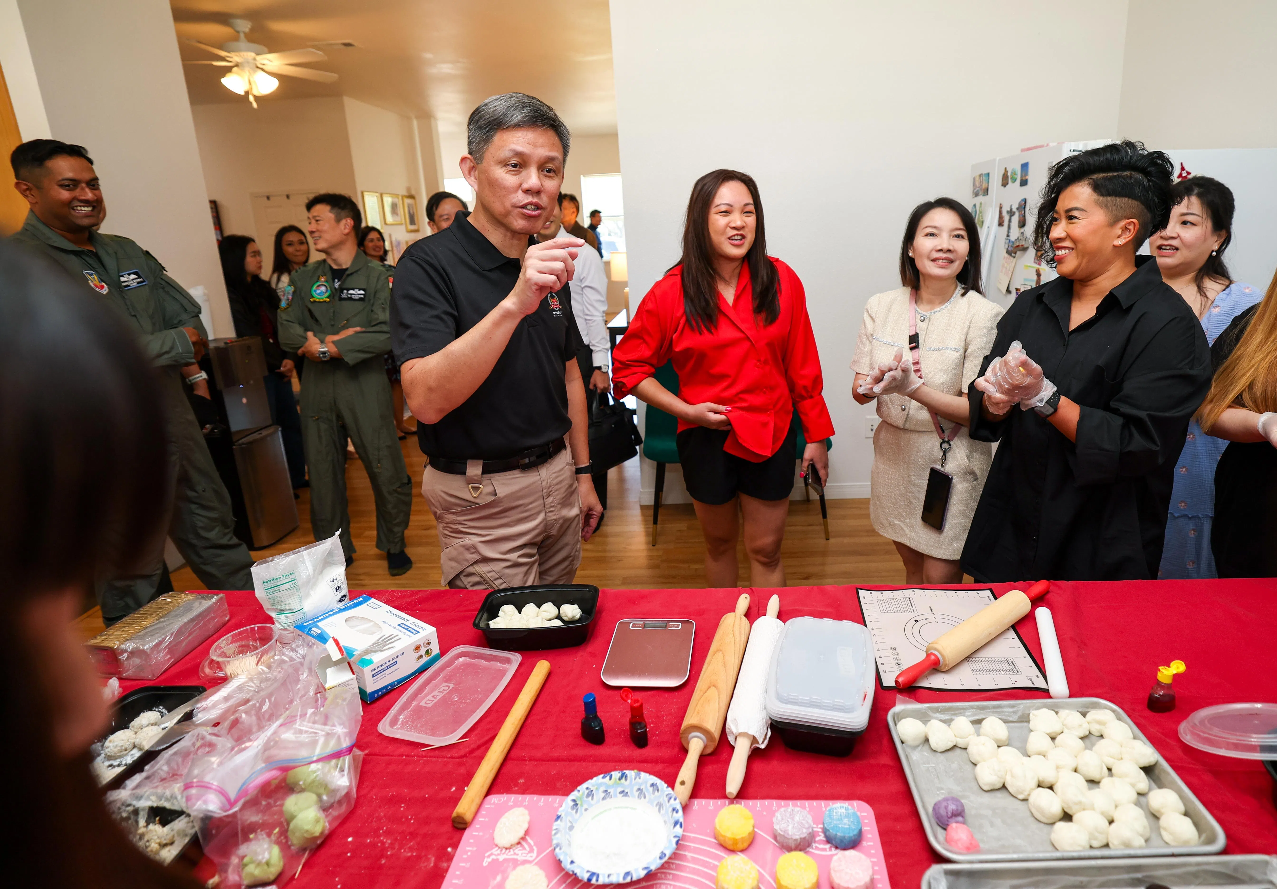 公共服务统筹部长兼国防部长陈振声在蒙廷霍姆与新加坡武装部队人员的家属交流。中秋佳节将近，这些家属正动手做月饼，让基地洋溢浓浓的节日氛围。（林明顺摄）