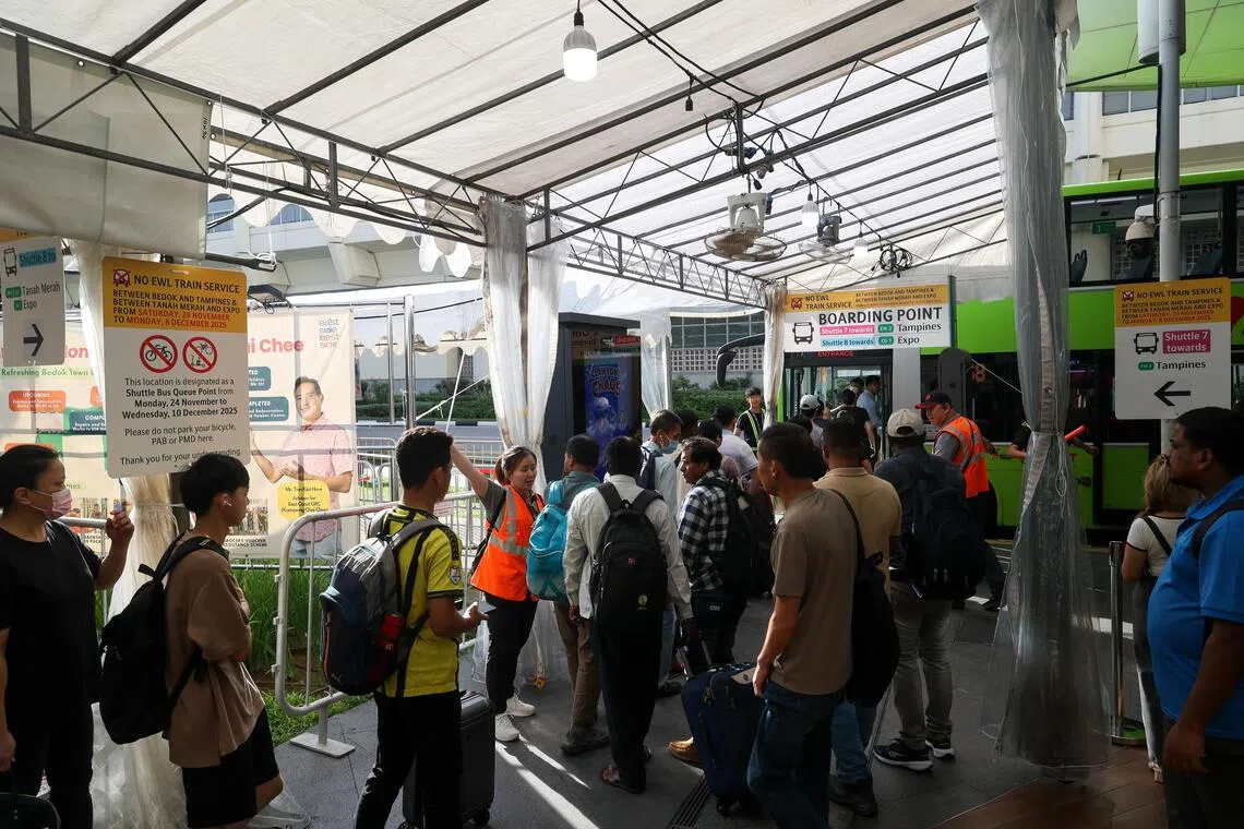 乘客在勿洛地铁站排队等候接驳巴士。（张俊杰摄）