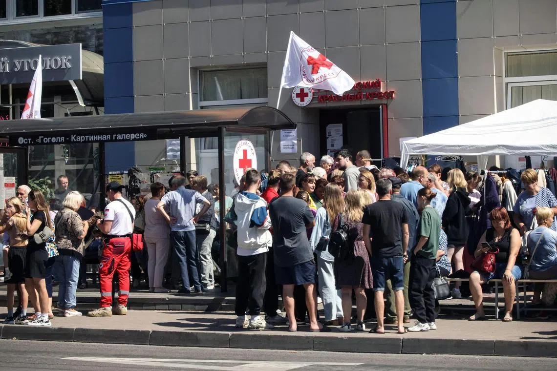 8月15日，库尔斯克居民到俄罗斯红十字会一处分发点领取生活物资。（法新社）