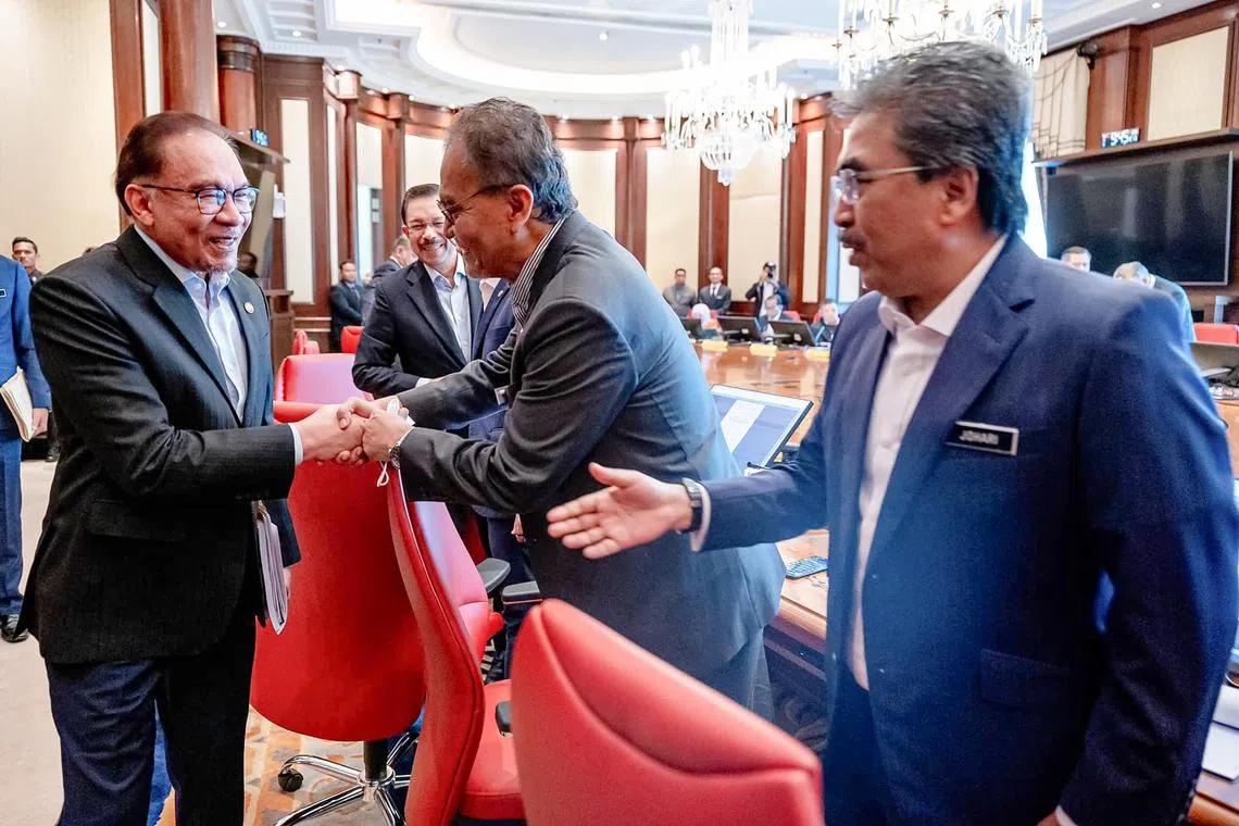 巫统副主席佐哈里阿都干尼（右）在内阁改组后担任种植及原产业部长，他也将继续领导一马公司特别委员会。图为首相安华（左）星期三召开内阁特别会议时，逐一与卫生部长祖基菲里（中）及佐哈里等与会者握手致意。（安华脸书照片）