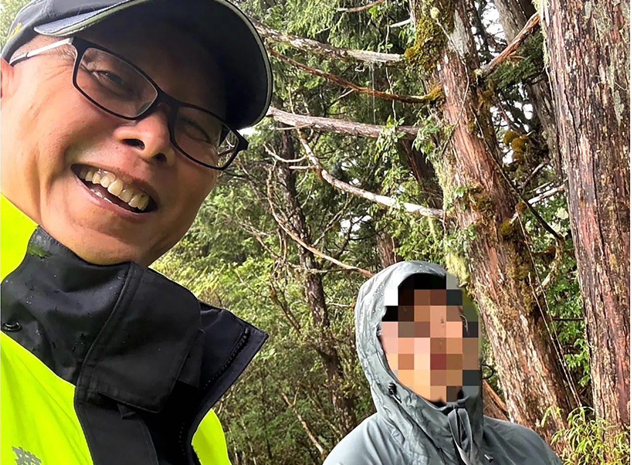 警员林玉堂（左）寻获狮城大学生时，对方已经体力透支。（取自网络）