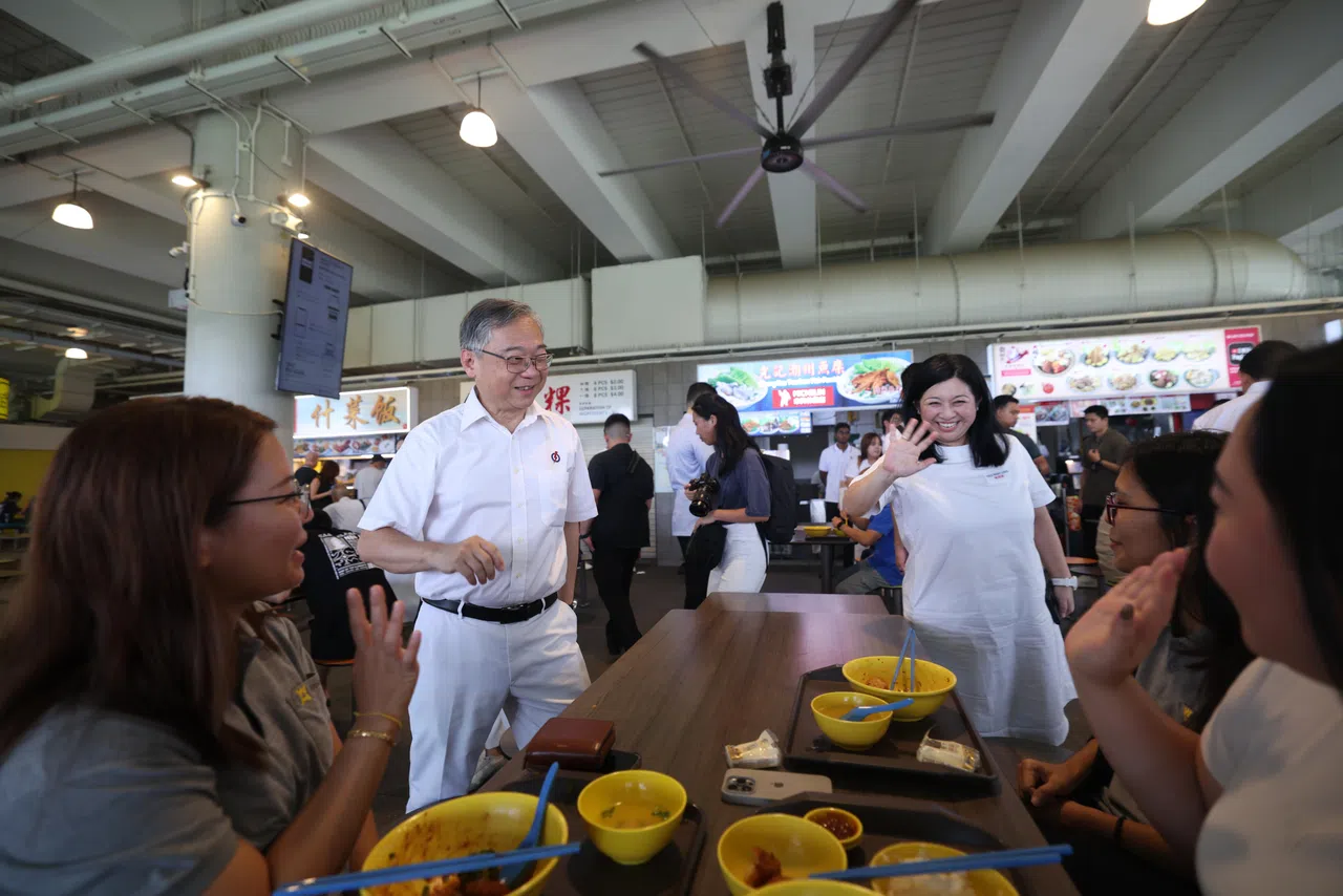 副总理兼贸工部长颜金勇（左二）和原白沙—榜鹅集选区议员杨涴淩（右三）一同走访熟食中心与选民交流，了解他们所关心的问题。（白艳琳摄）