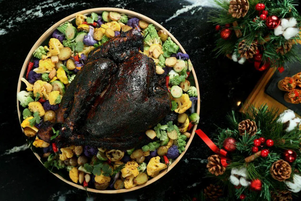 喜来登酒店以娘惹菜常用的黑果，烹制“黑钻石烤火鸡”。（龙国雄摄）