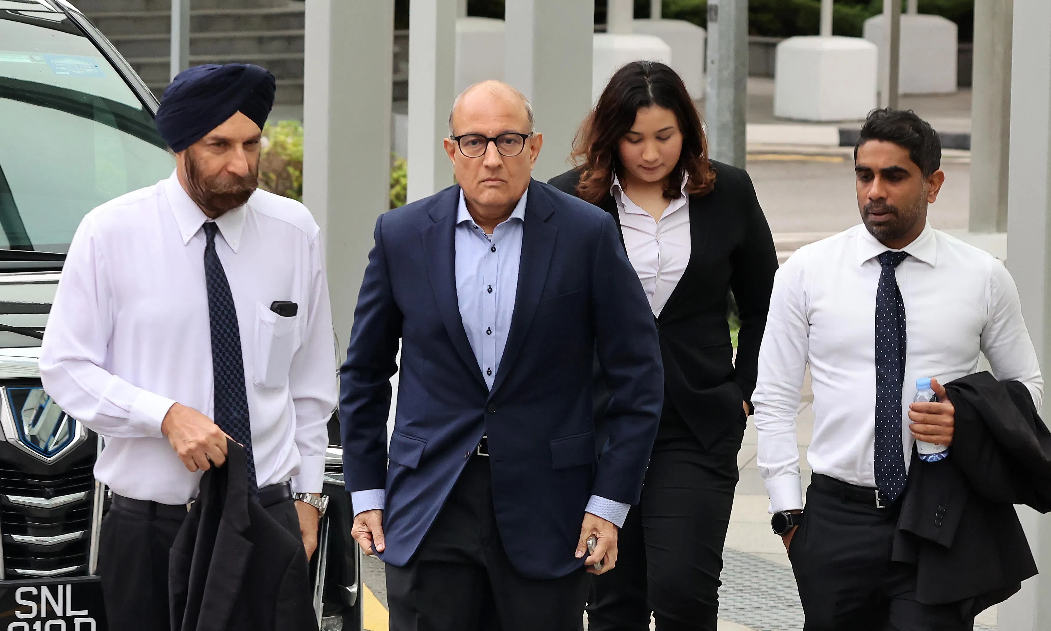 易华仁（左二）星期四（1月18日）上午8时10分，在律师团队的陪同下抵达国家法院。（唐家鸿摄）