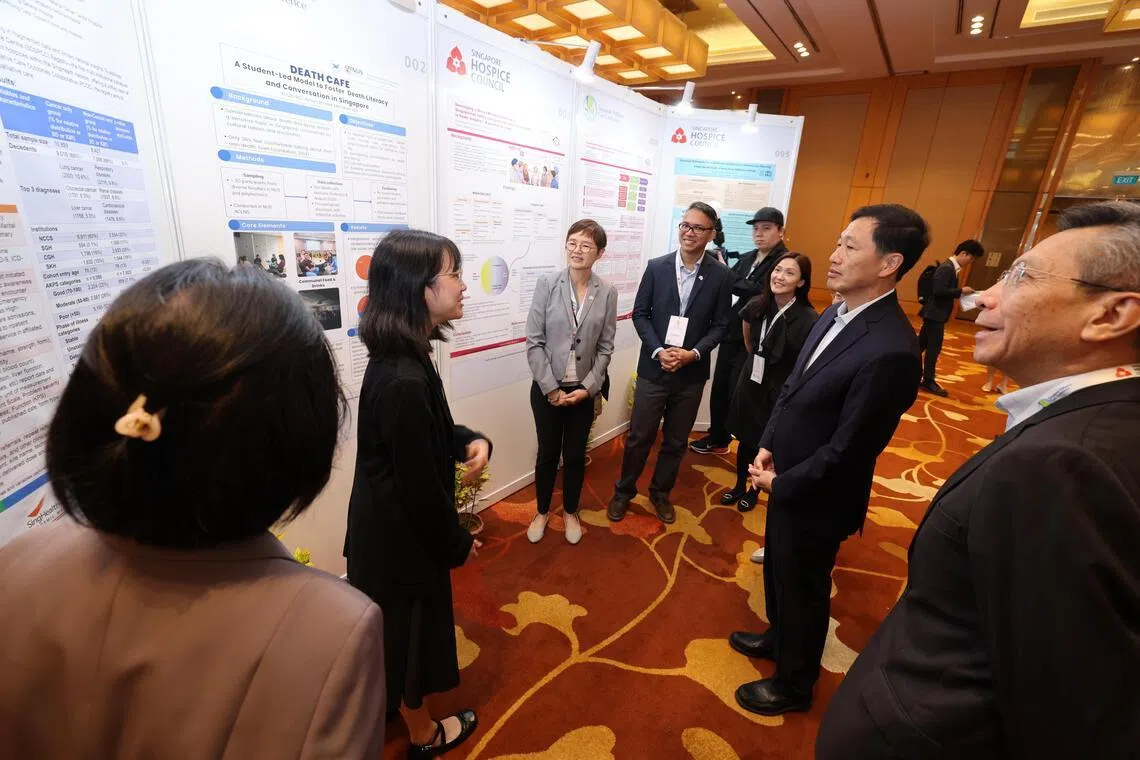 社会政策统筹部长兼保健卫生部长王乙康（右二）在新加坡慈怀理事会主席周永明（右一）等人陪同下，参观新加坡慈怀疗护大会展览。（梁麒麟摄）