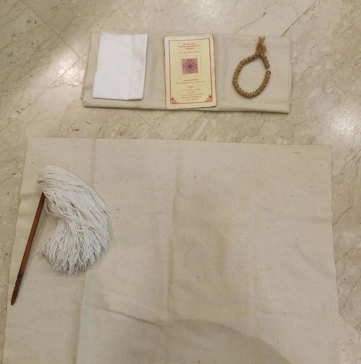 耆那教徒家中必备白布、小扫帚、遮嘴小白布、念珠和经书。（陈爱薇摄）