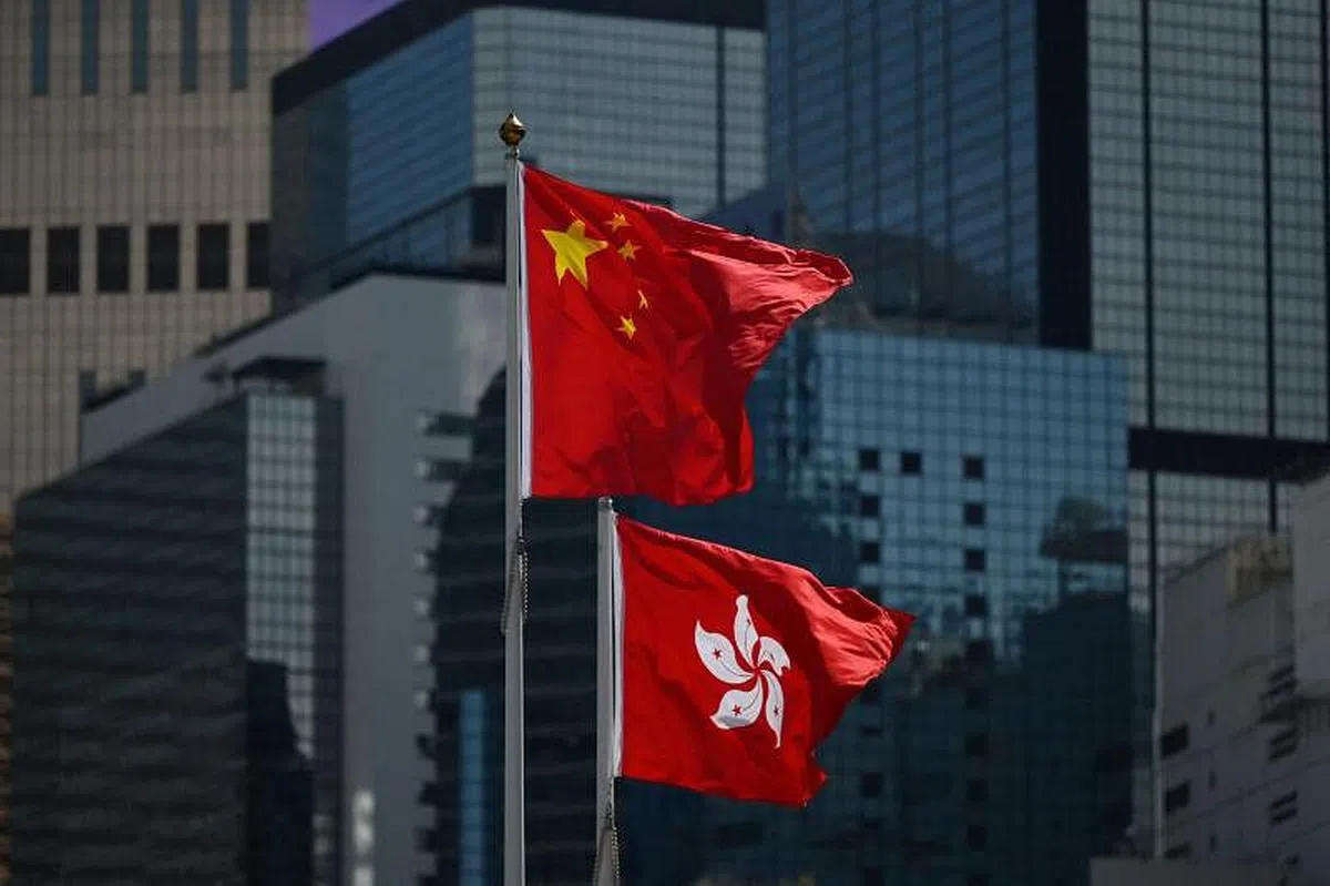 中国国旗和香港特别行政区区旗，共同竖立在香港市区。（法新社）