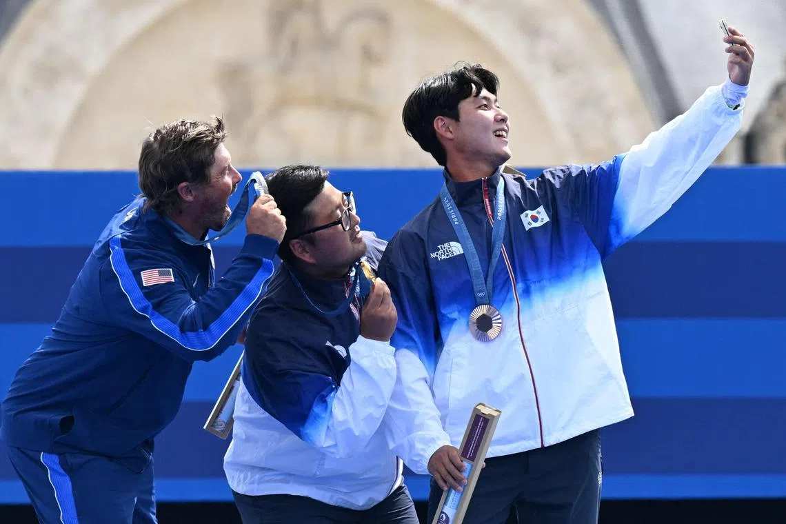 埃里森（左起）、金优镇和夺得铜牌的另一名韩国选手李宇锡，在领奖台上合照。（法新社）