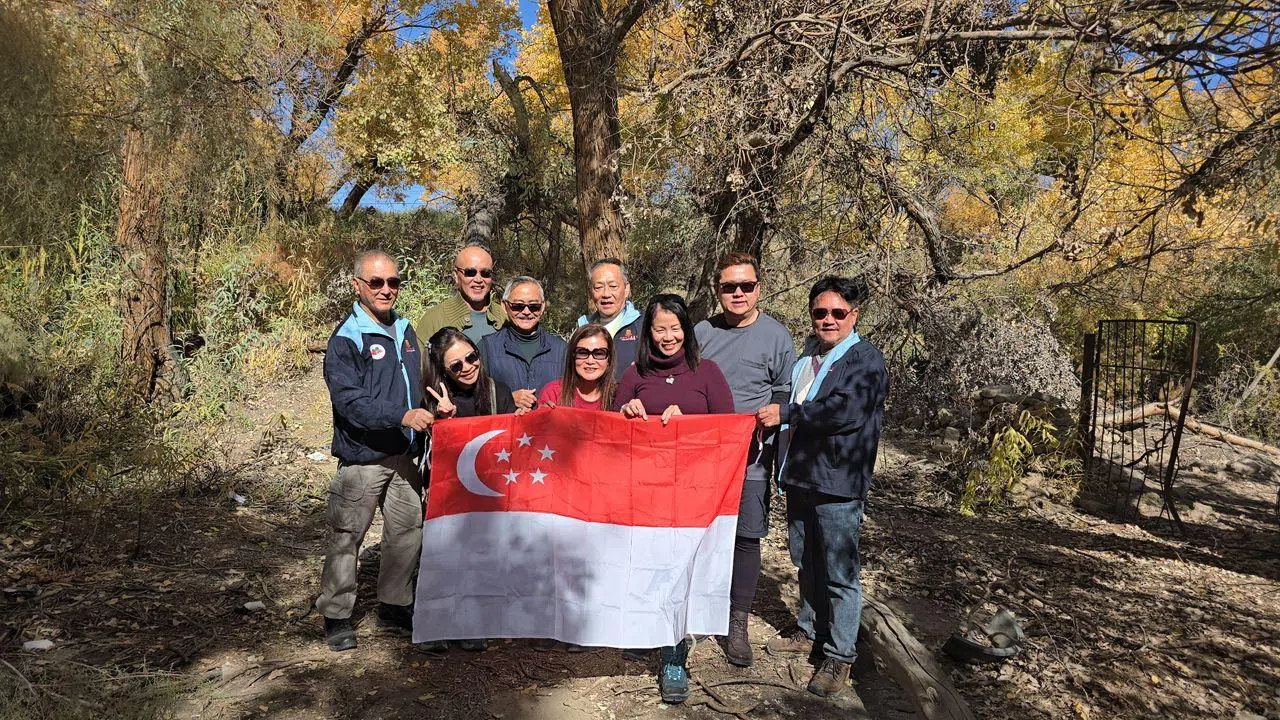九名新加坡河婆集团会员从中国新疆乌鲁木齐出发，途径木垒胡杨林时留影。（河婆集团提供）