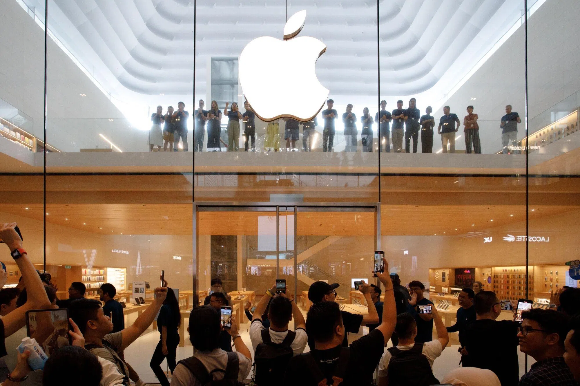 马国近年来开始生产苹果公司的部分平板电脑iPad，也逐渐成为苹果公司在东南亚日益重要的销售市场。6月22日，苹果在吉隆坡的首家直营商店开业，人们聚集在店外拍照。（彭博社）