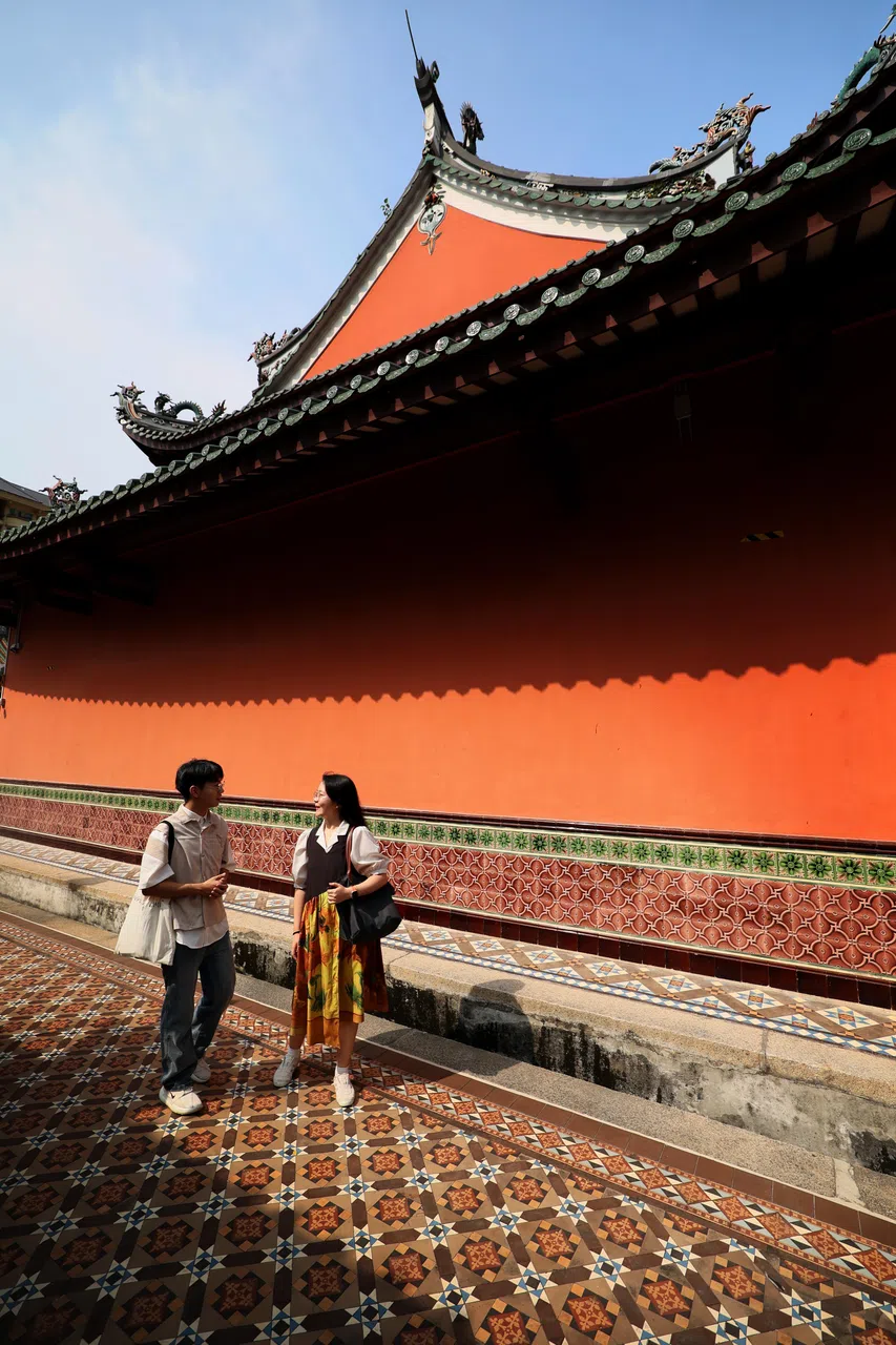 在天福宫对谈，郭一（左）和韩欣楠（右）谈到天福宫木门上的马来族门神，也讲福德祠博物馆门口沧海桑田的变迁。（龙国雄摄）