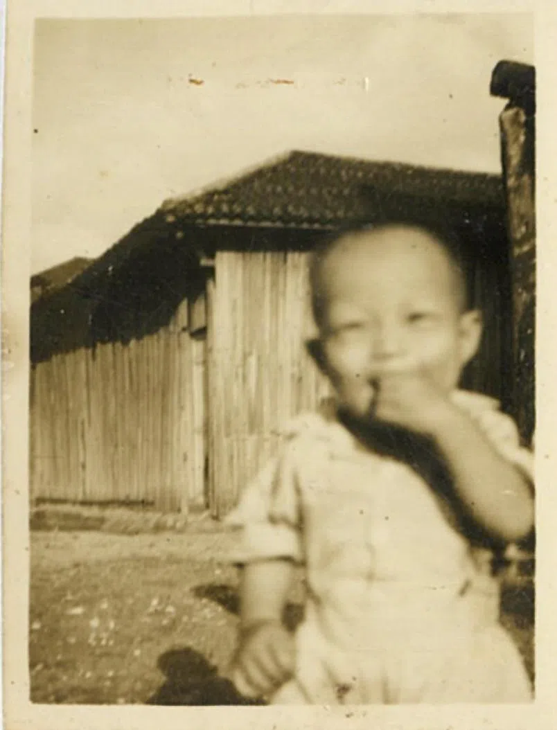 两岁的黄国松站在港脚渔村邻居家门前。（黄国松提供）