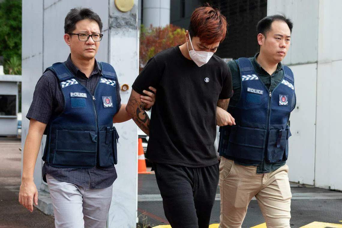 涉案的两名新加坡男子星期五（6月30日）引渡回国，图为其中一人被警察押走。（新加坡警察部队提供）