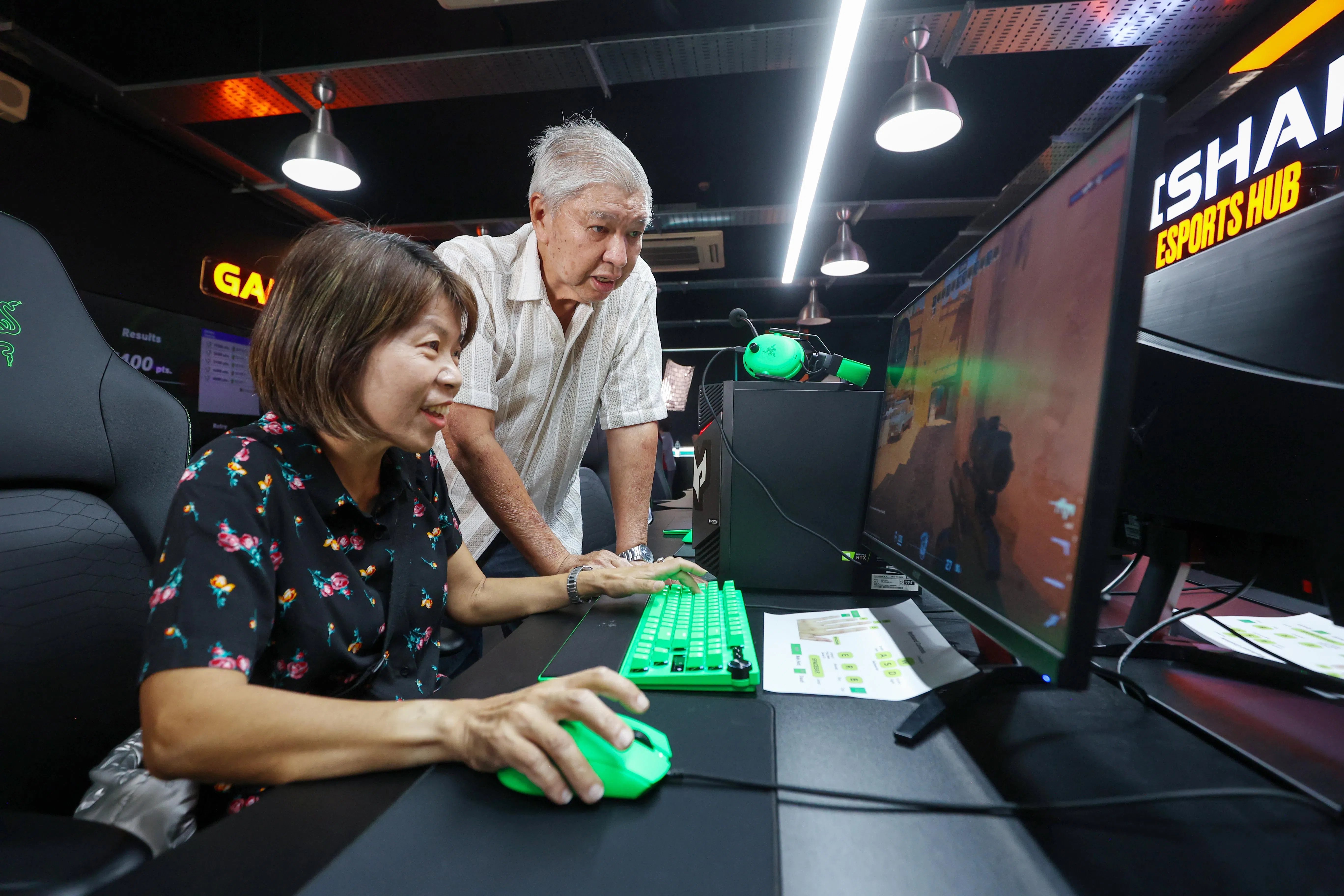 碧山居民陈黛玲（左）一个多月前经电竞战队Squad 2x2成员陈德良（右）介绍，开始接触《反恐精英2》射击游戏。（游甯稀摄）