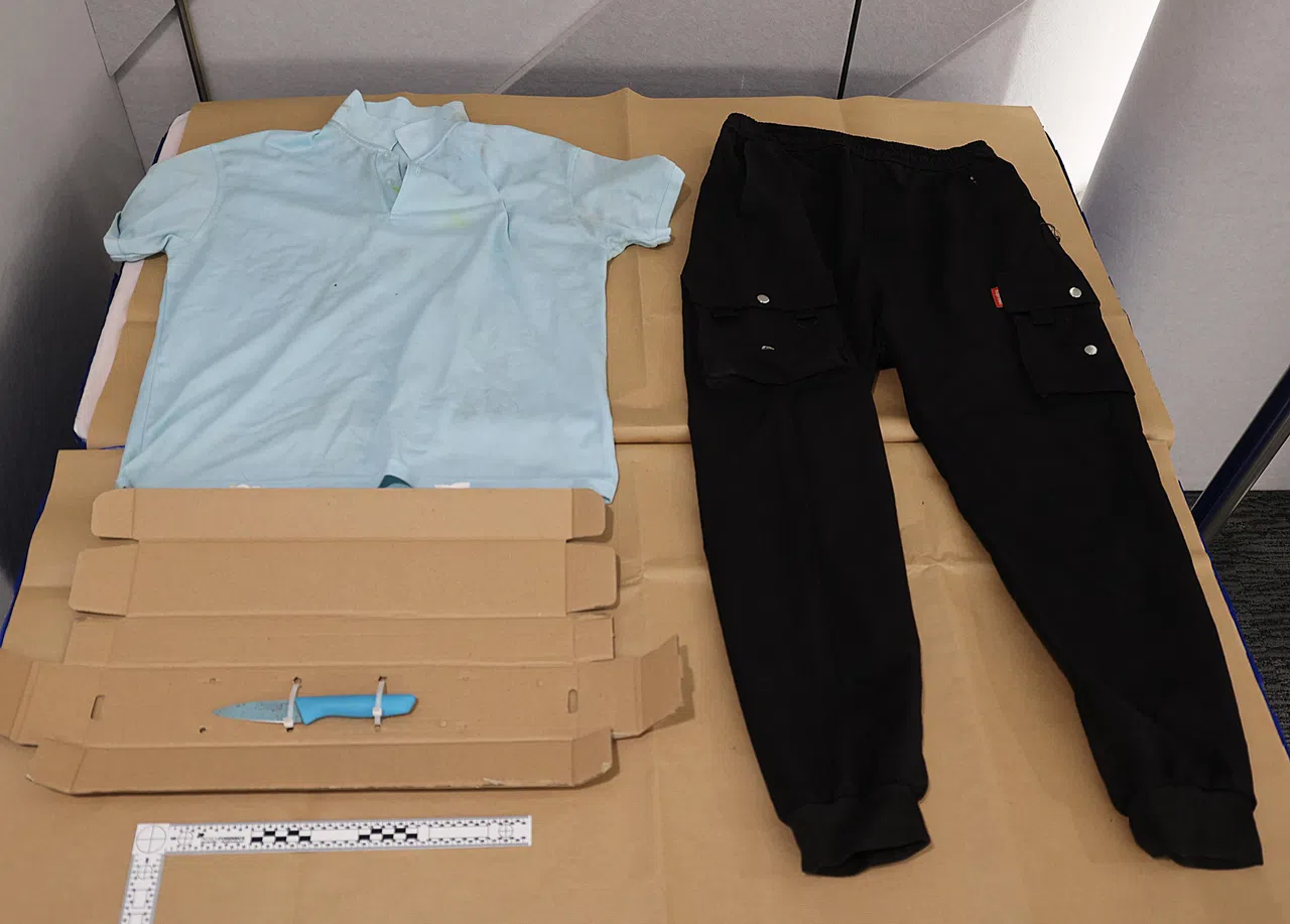 警方在记者会上展示起获的证物，包括一把水果刀，以及被告干案时穿的蓝色Polo衫和黑色长裤。（档案照片）