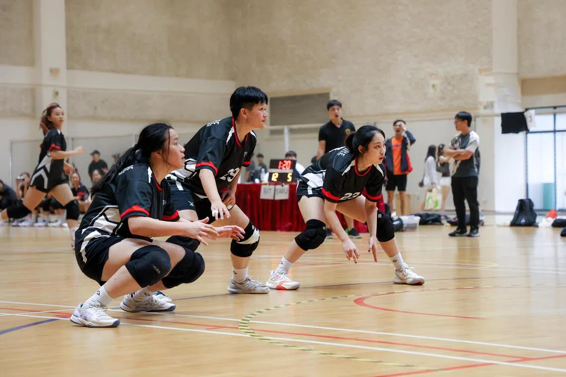 三名黑衣球员防守反弹架，准备接住反弹球以阻止对方得分。（游甯稀摄）