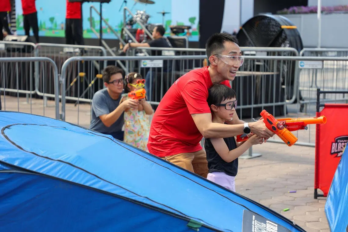 在“爸爸外出日”的活动上，41岁的王伟文和女儿一起玩泡沫玩具枪游戏。（陈心媛摄）