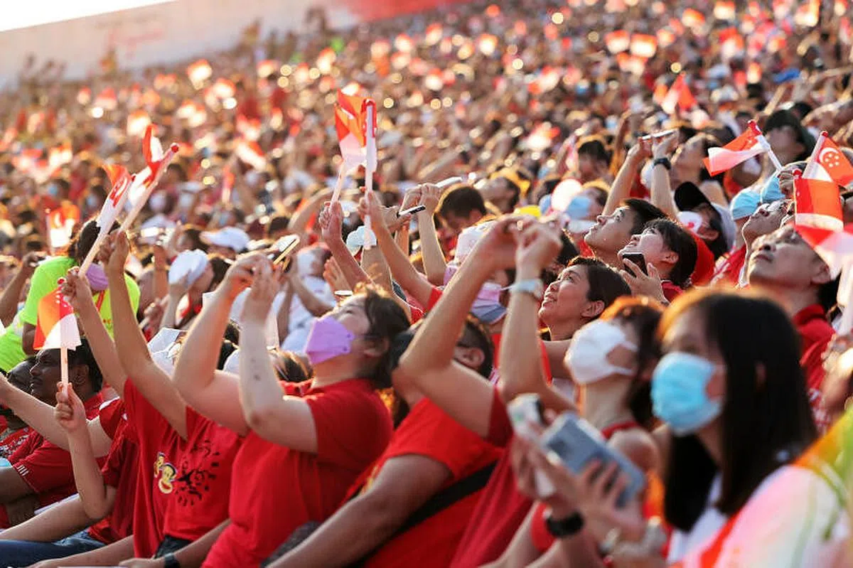 今年的国庆庆典在滨海湾浮动舞台举行，庆祝新加坡建国57周年。当“红狮” 在高空出现，现场观众纷纷拿出手机或相机，捕捉跳伞队员降落的精彩瞬间。（梁麒麟摄）