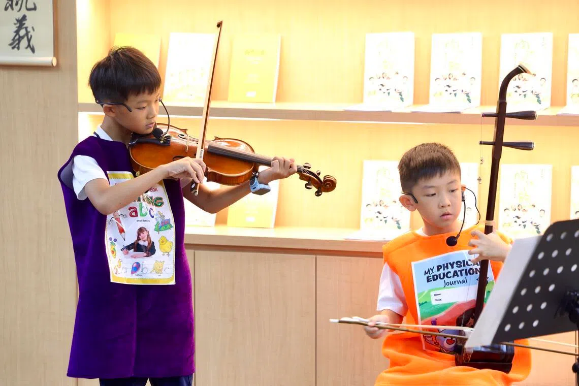 诗社表演结合孩子们的才艺，郑雨骏（左）和连同兆用乐器开启下一幕。（陈斌勤摄）