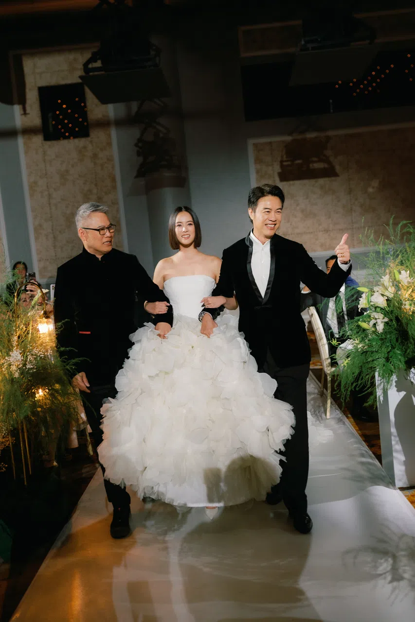 郑颖（中）由亲爹郑各评（右）和干爹洪伟文挽着入场。（Antelope Studios提供）