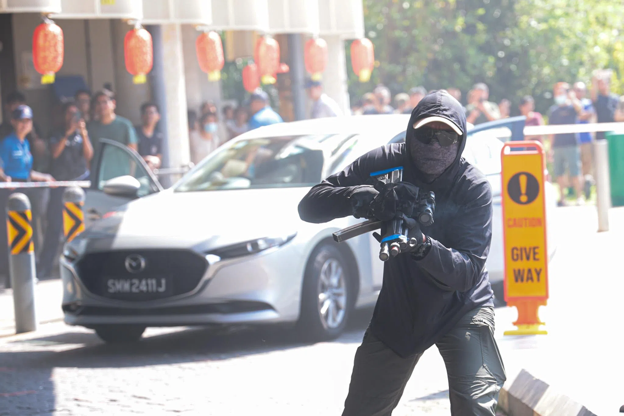 演习开始，一名可疑人物逐渐靠近一辆车，车子随即起火，冒起浓烟，吸引大量群众围观。随后，两名持冲锋枪的男子朝食客开枪，造成四人受伤。（李冠卫摄）