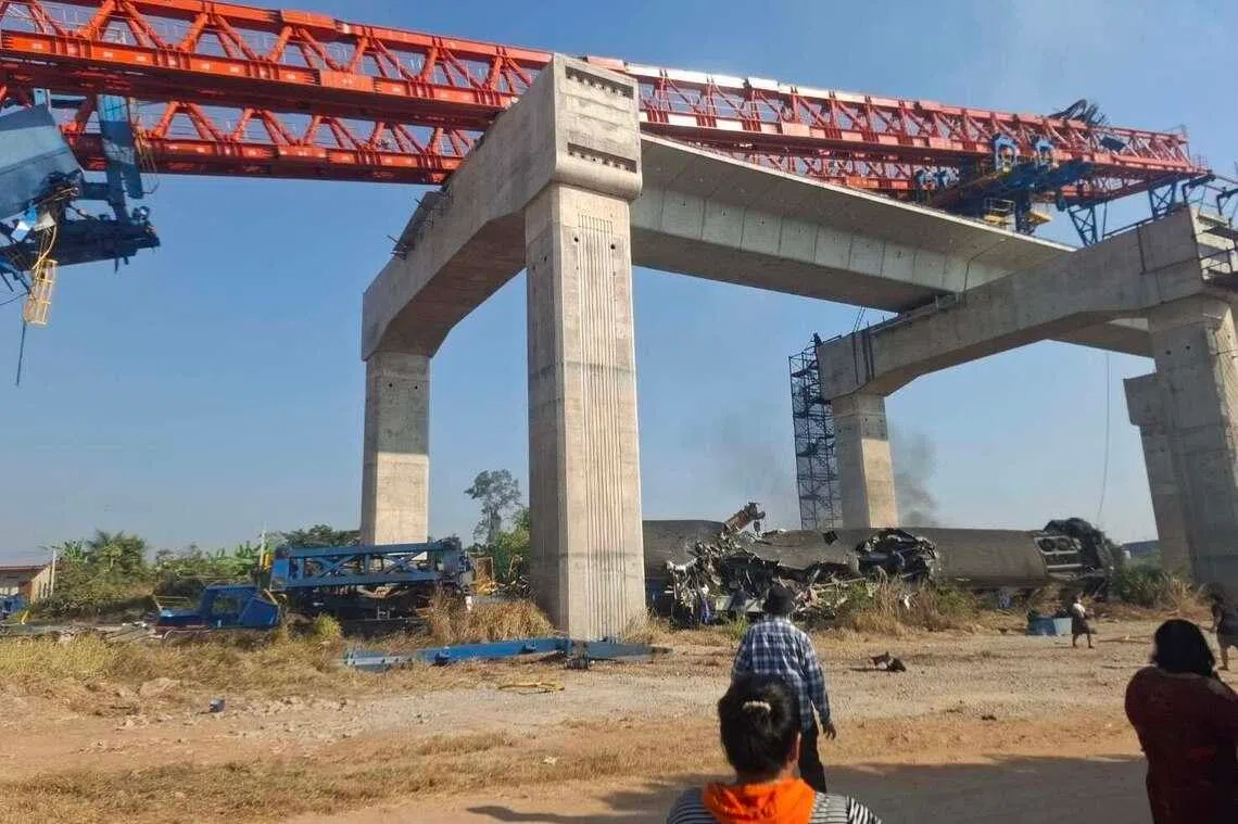 现场照片显示，起重机从施工中的高铁高架桥坠落，砸毁在桥下行驶的列车，碰撞导致起火。（取自泰国消防部门脸书）