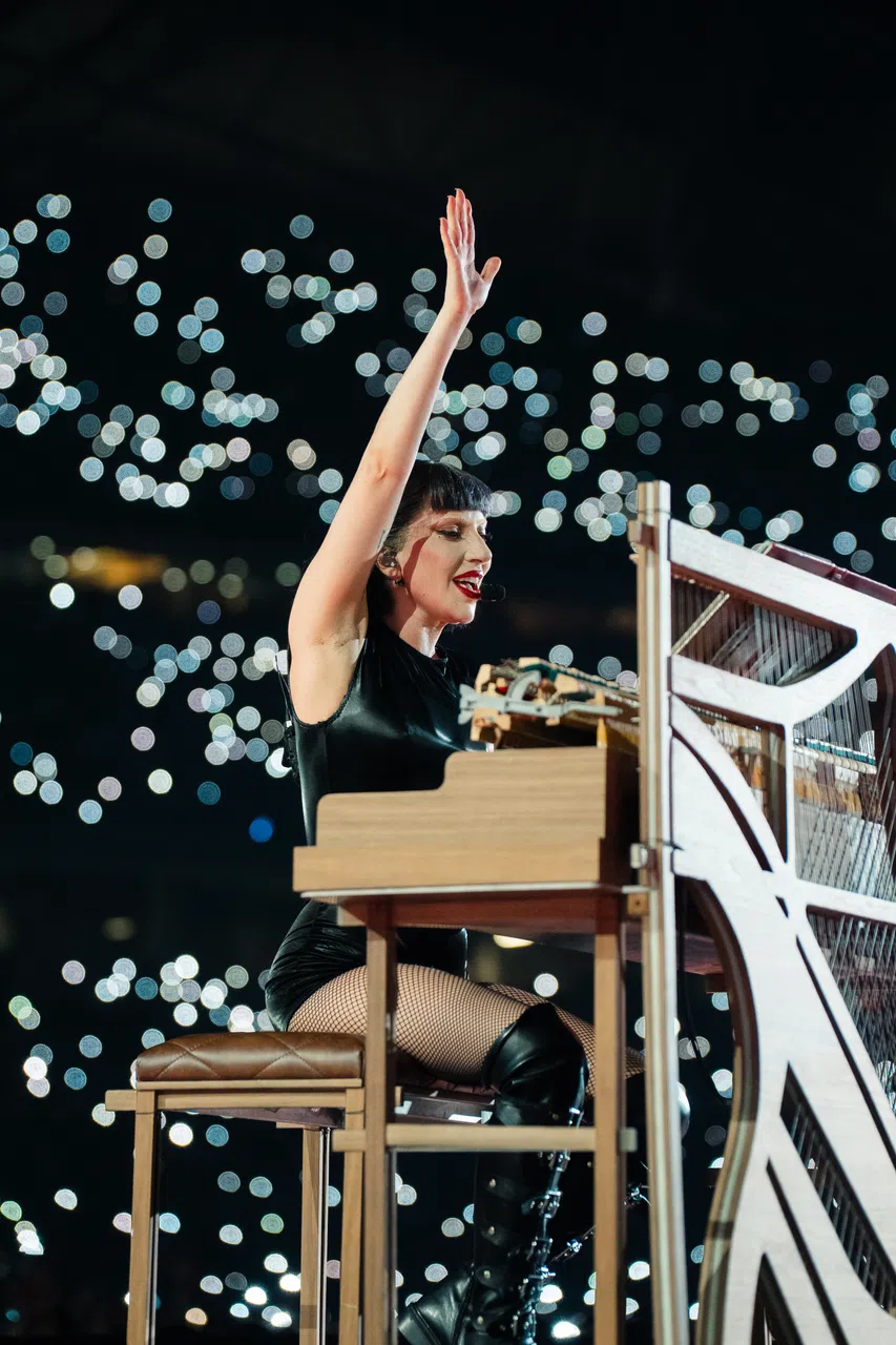 Lady Gaga在钢琴前深情演唱，粉丝在台下用手机的光为偶像应援。（Live Nation提供，Hoong Qi Hao摄）